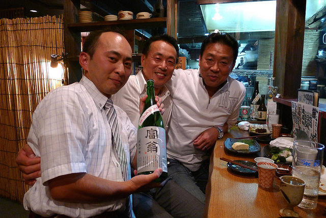 北川本家杜氏田島さん（中）と、丹州山田錦無濾過生原酒を手にする蔵人の中村さん（左）